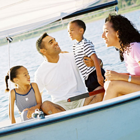 family sitting in boat on lake