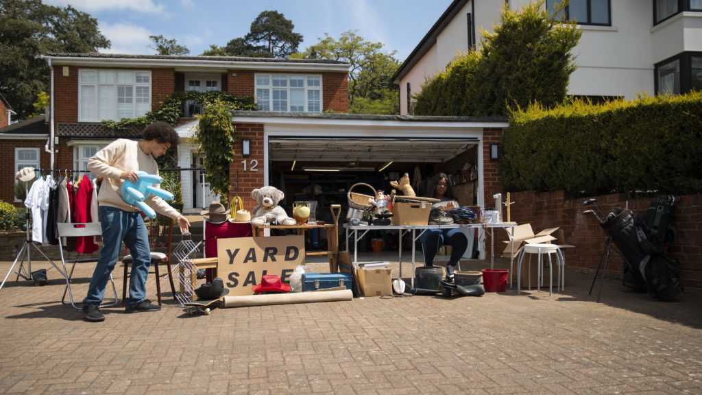 man-setting-up-yard-sale; 37.78574185377311, -121.3079252049677